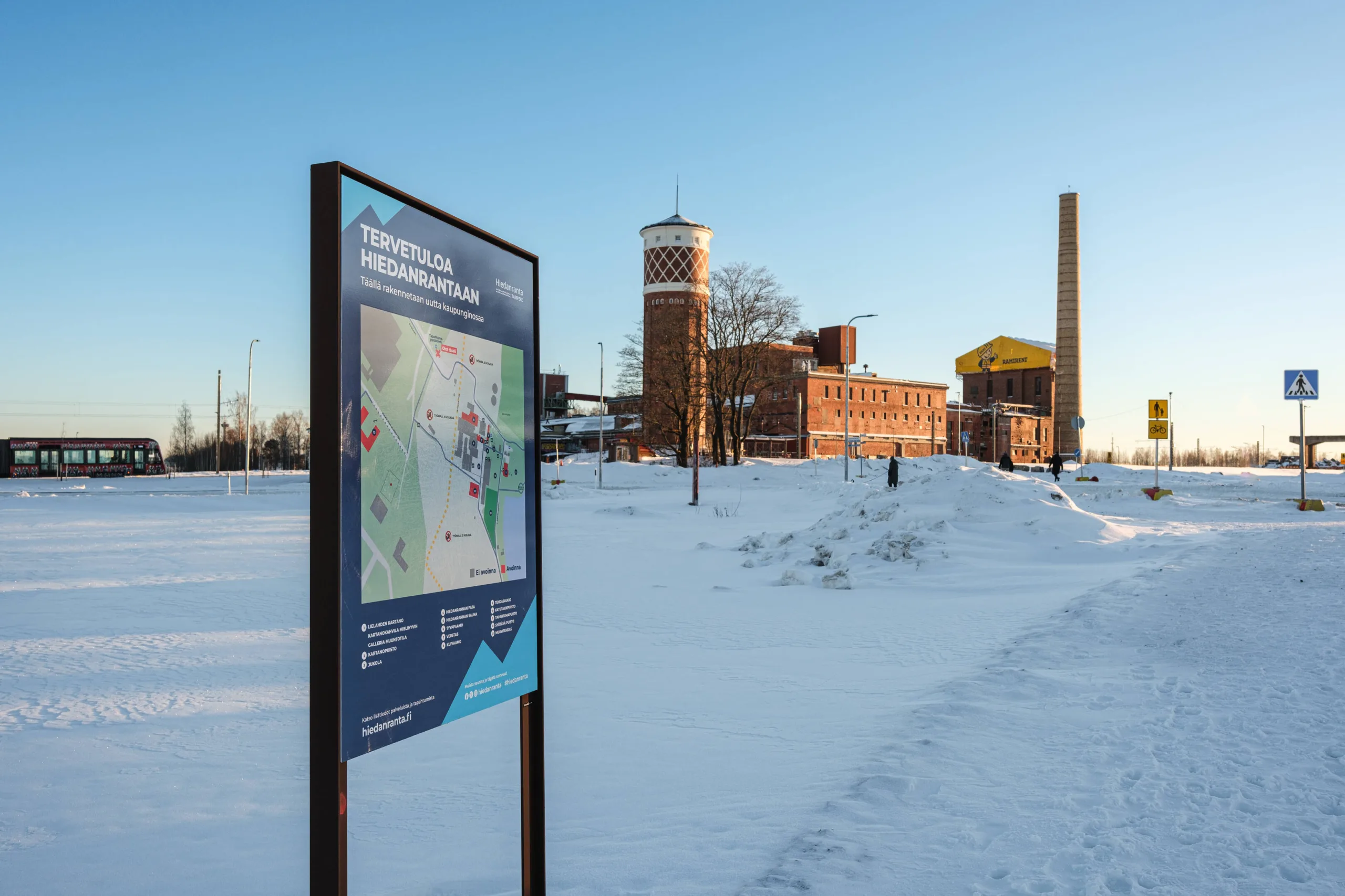 Alueopasteessa on kartta Hiedanrannasta. Taustalla näkyy vanha vesitorni ja tehdasrakennuksia.