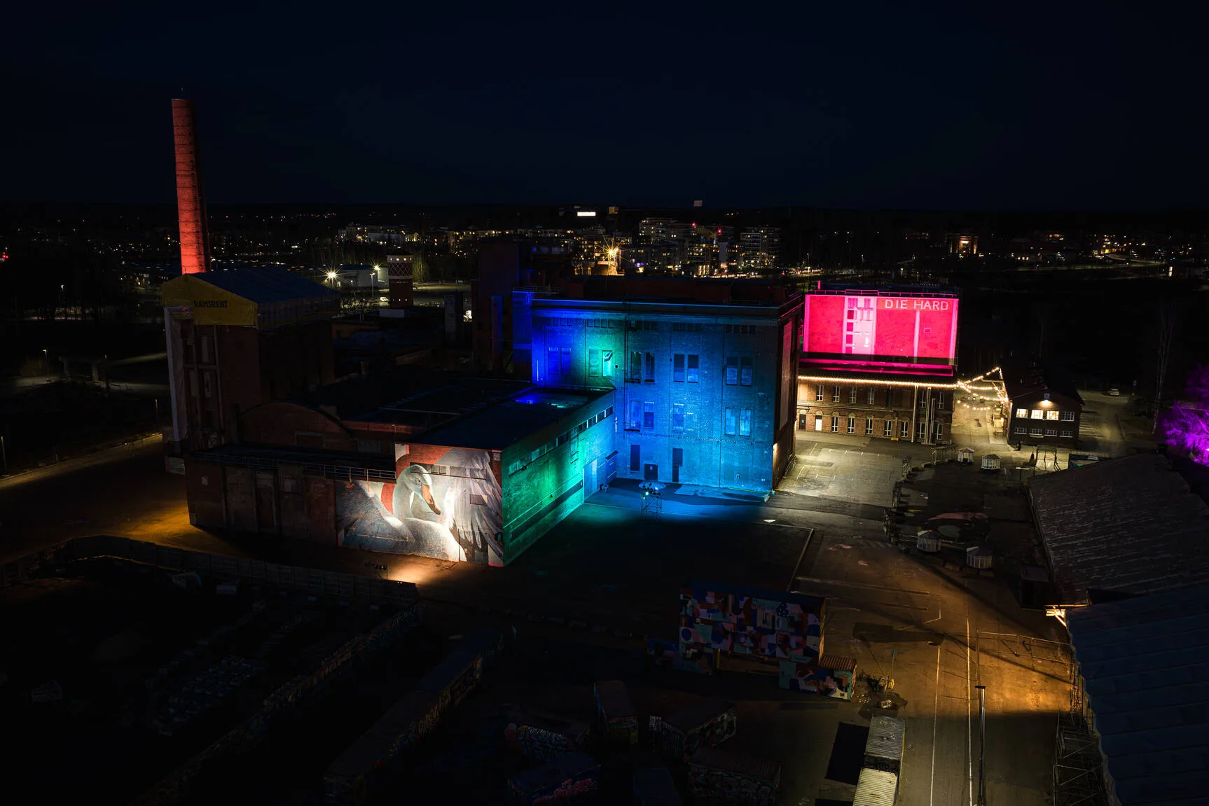 Vanhoihin tehdasrakennuksiin heijastettiin erivärisiä valoja, jotka näkyvät hyvin pimeällä.